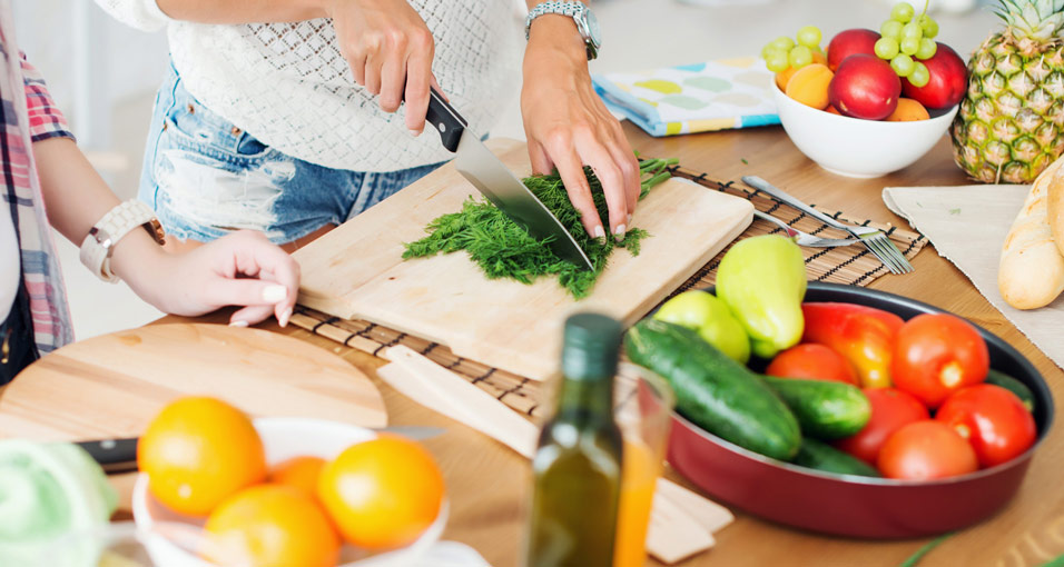 Frau beim Schneiden von Petersilie als Beispiel für die Ernährung bei Diabetes